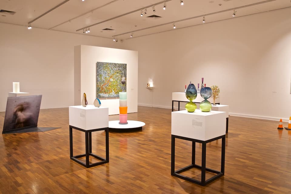 Une galerie d’art dotée de planchers en bois et de murs blancs.
