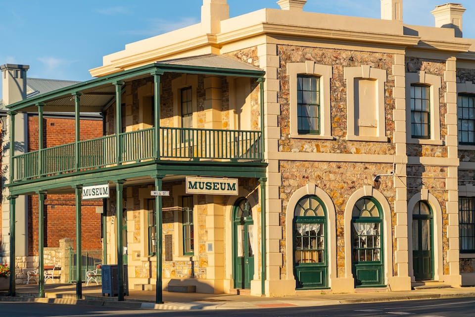 Un edificio histórico con un balcón verde y un letrero que dice 'Museum'.