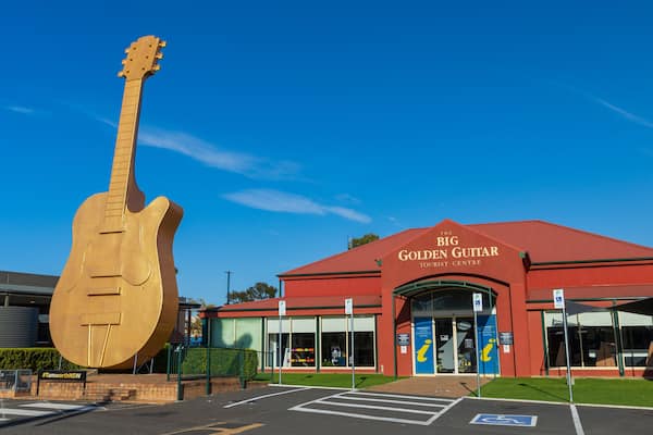 Big Golden Guitar Tourist Centre featuring signage and a monument