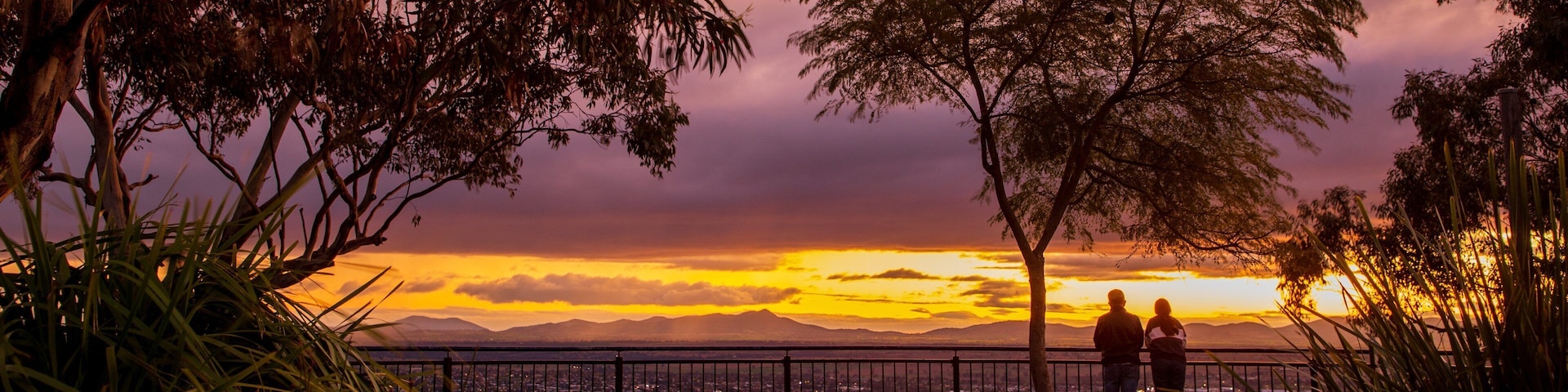 Oxley Scenic Lookout featuring a sunset and views as well as a couple
