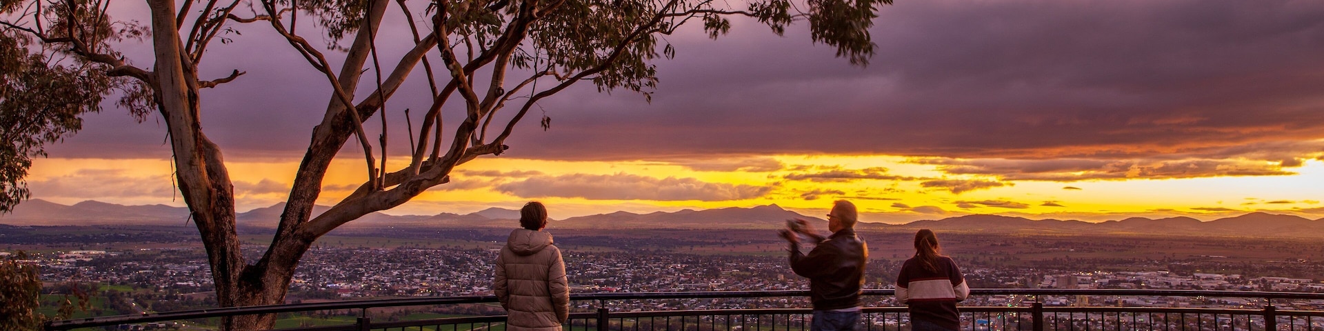 Oxley Scenic Lookout featuring views and a sunset as well as a small group of people