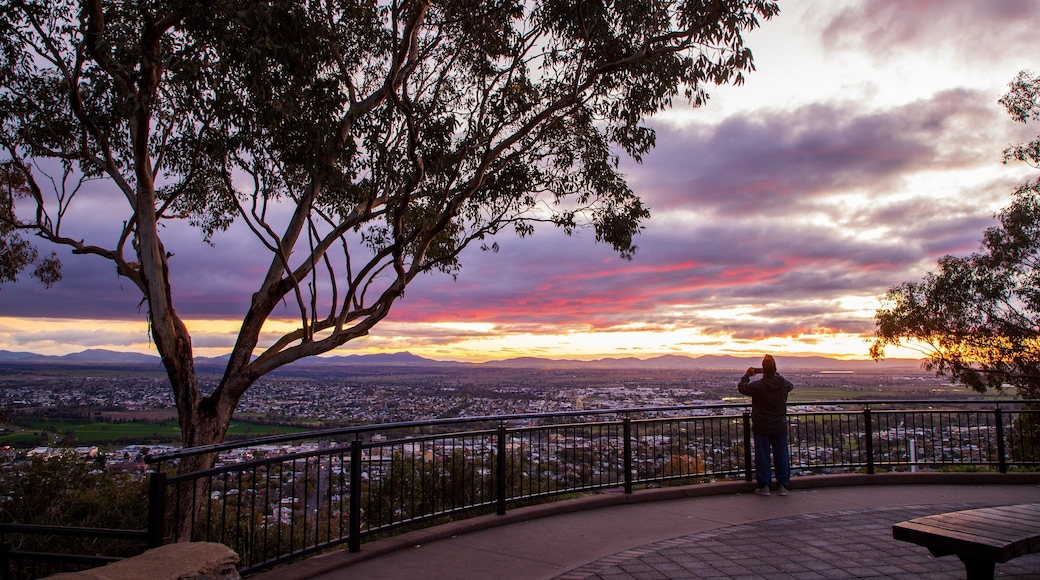 Oxley Scenic Lookout featuring a sunset and views as well as an individual male
