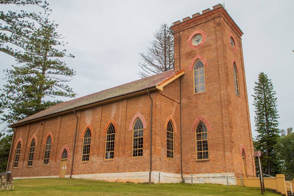 A large brick church with arched windows and a clock tower.