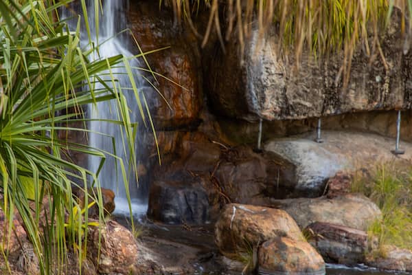 Ein Wasserfall stürzt über Felsen in einer naturnahen Landschaft.