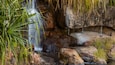 Una cascata che si getta su rocce in un ambiente naturale.