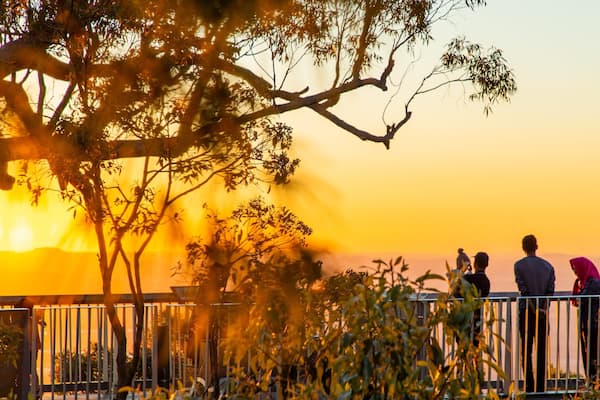 Mt Archer showing a sunset and views as well as a small group of people