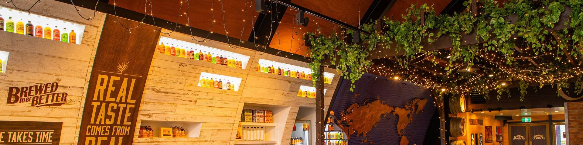 A brewery display with wooden shelves, a refrigerated section, and stacks of beer boxes.