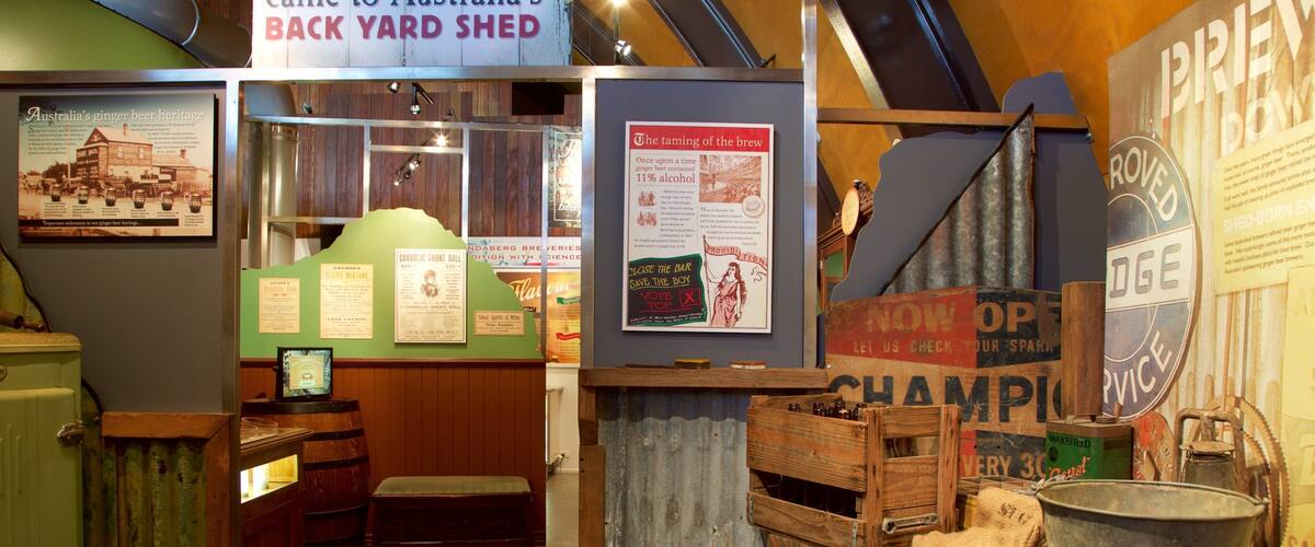 A rustic bar with vintage decor, including a checkered floor, wooden barrels, and historical posters.