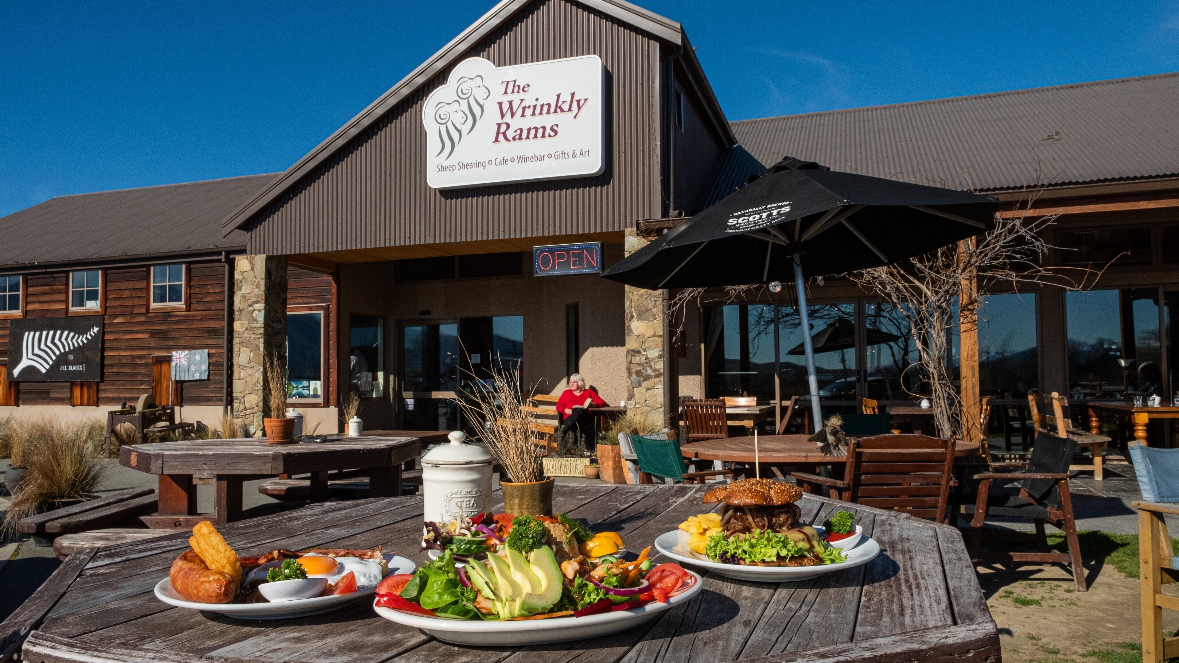 The Wrinkly Rams restaurant with outdoor seating and a variety of food displayed on a wooden table.