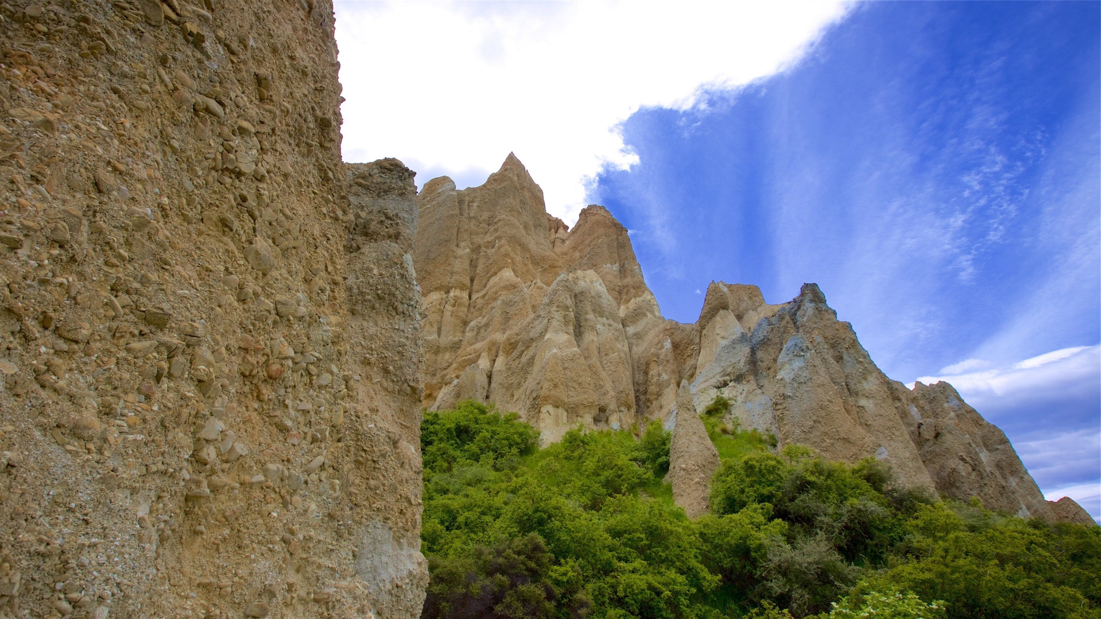 A rocky mountain landscape with green vegetation at its base.
