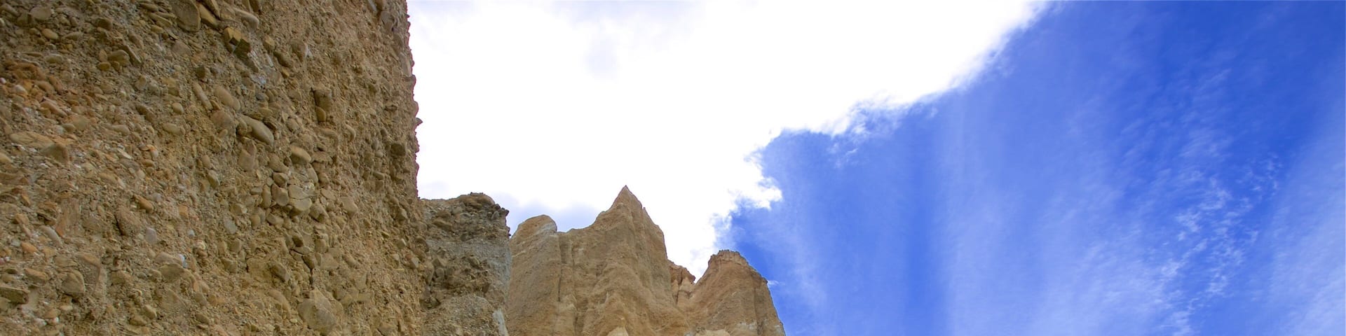 A rocky mountain landscape with green vegetation at its base.