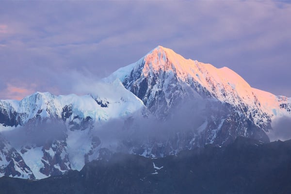 Fox Glacier som inkluderar berg och en solnedgång