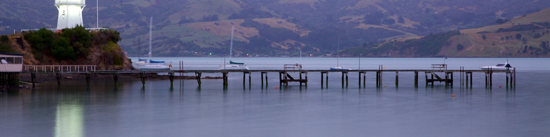 Akaroa Lighthouse which includes a lighthouse, tranquil scenes and a sunset