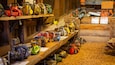 A collection of chainsaws and other equipment on wooden shelves in a workshop.