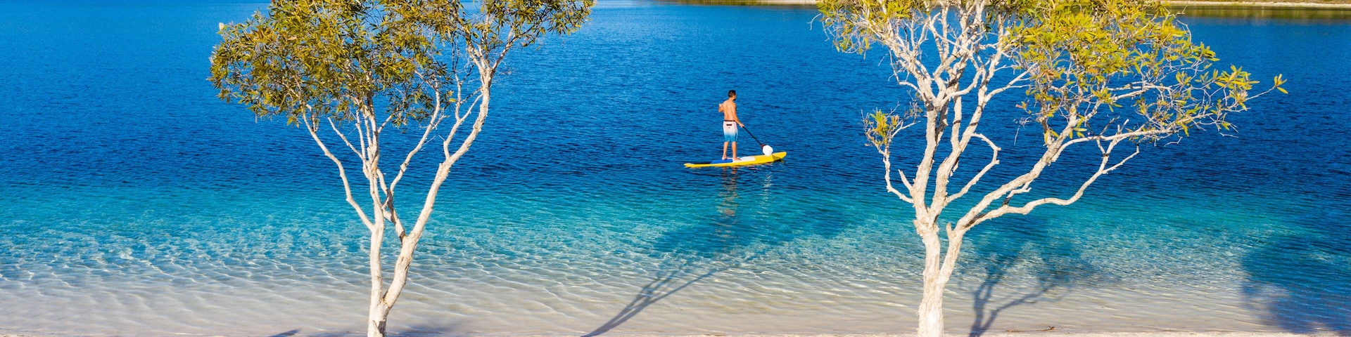 Stand up paddle boarding on Lake Mckenzie, Fraser Island