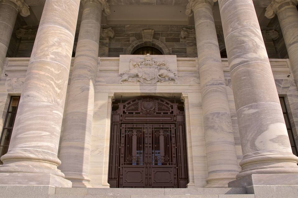 A grand entrance with large columns and a detailed coat of arms above the door.