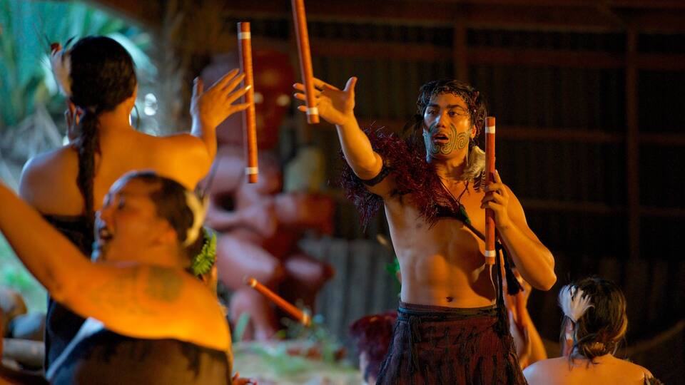 A group of people in traditional attire holding wooden sticks, likely participating in a cultural event or ceremony.