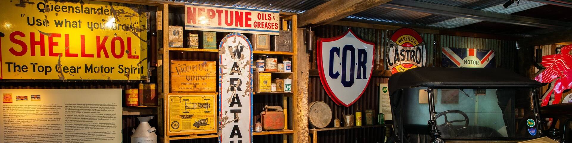 A vintage car exhibit with old signs and memorabilia.