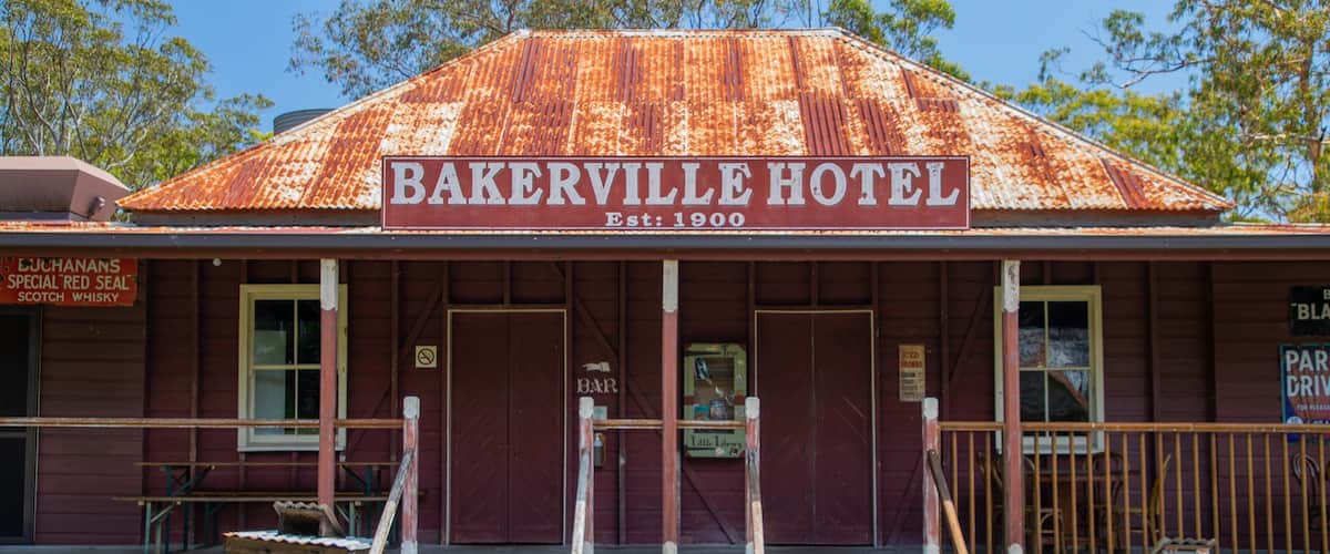 A rustic building with a sign reading "Bakerville Hotel Est. 1900".