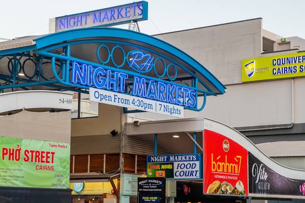 The Night Markets sign with neon lights, a food court sign, and a banner for Phô Street Caisns.