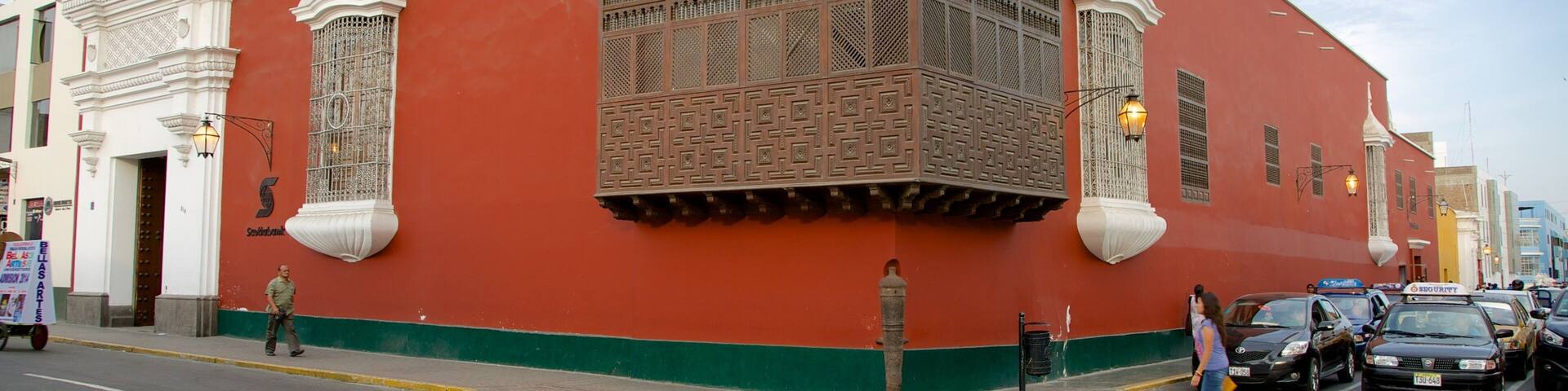 A red building with ornate windows and a green base.