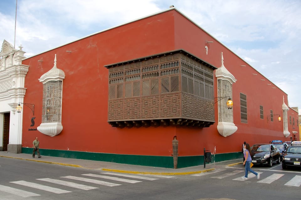 A red building with ornate windows and a green base.