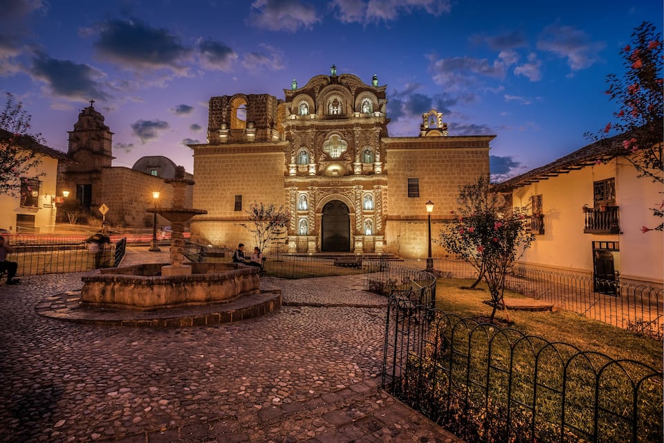 A historic church with intricate architecture and a cobblestone courtyard.