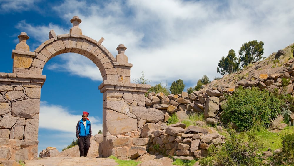 A stone archway with a person walking through it.