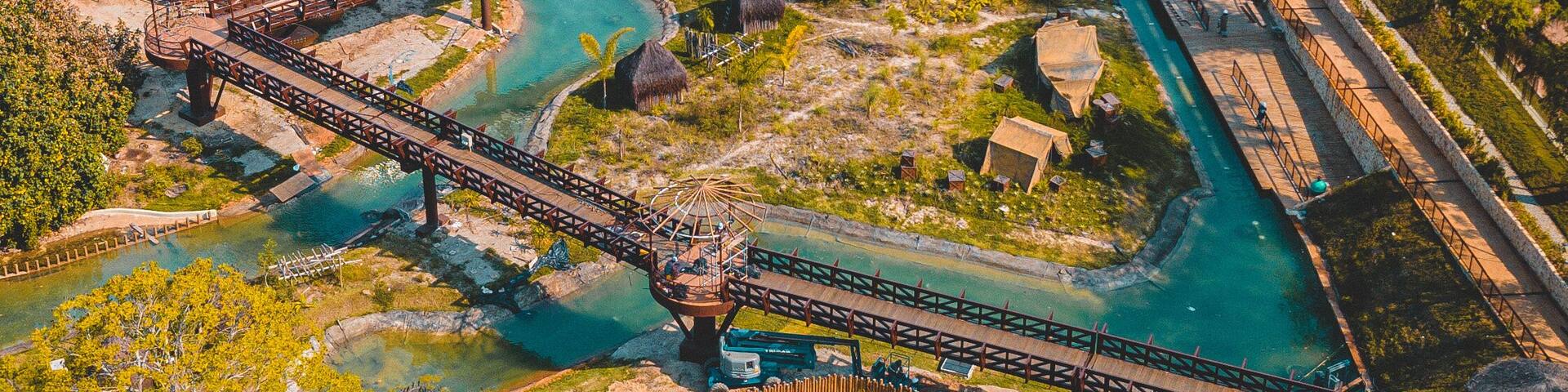 Un parque con un puente, fuentes de agua y edificios al fondo.