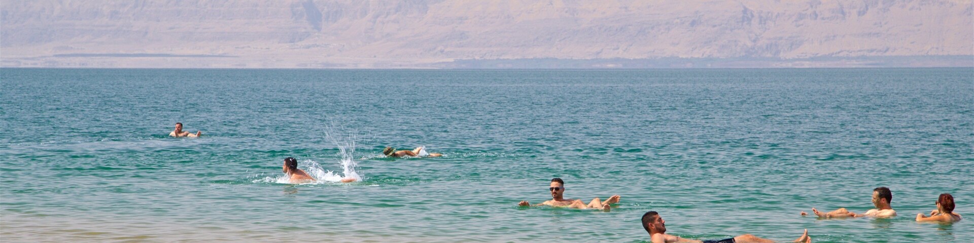 Amman Beach featuring swimming and general coastal views as well as a small group of people