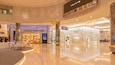 Ein moderner Einkaufszentriale Innenraum mit Geschäften von Louis Vuitton und Dior.