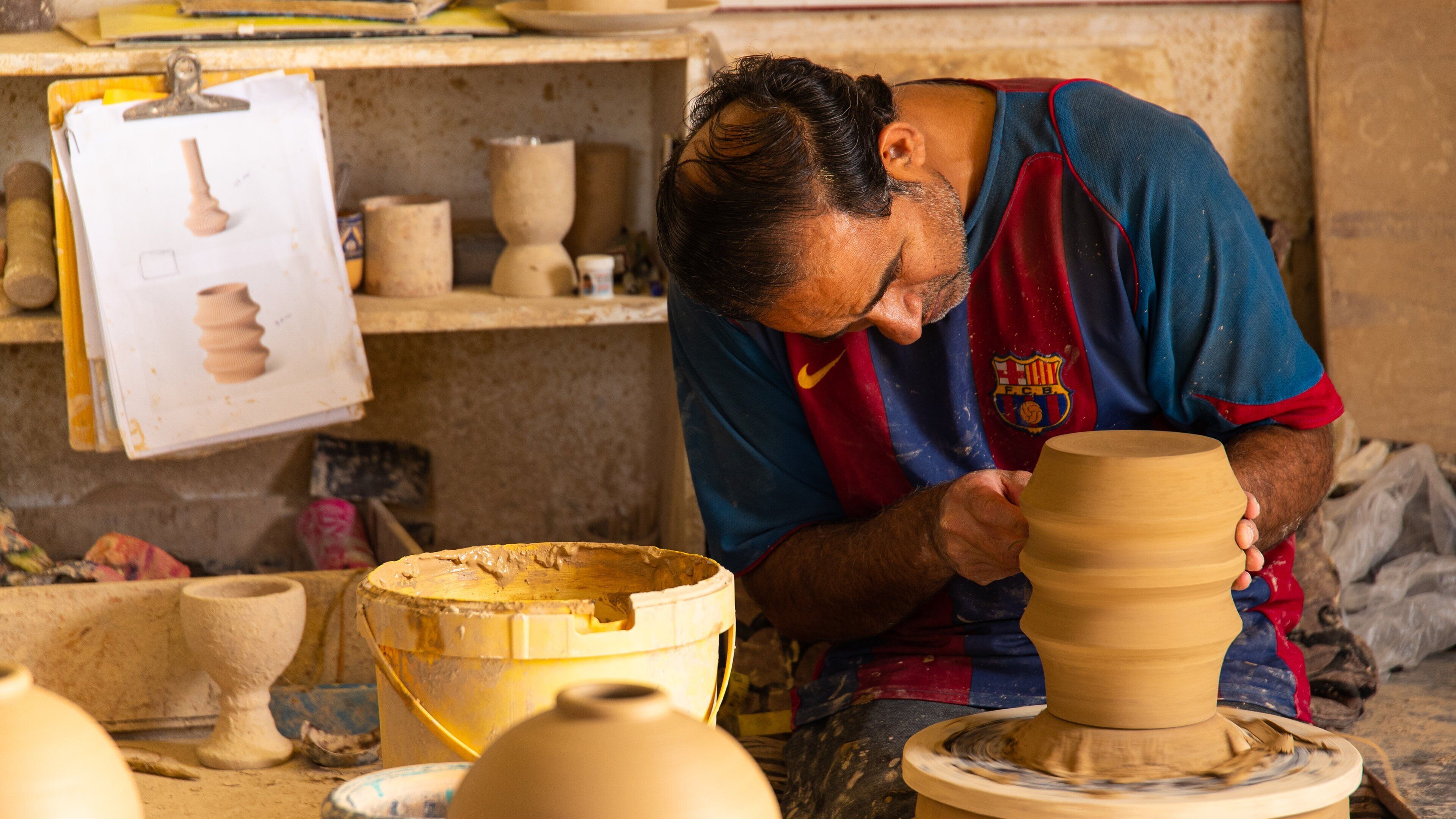 A pottery workshop with clay pots and a pottery wheel.