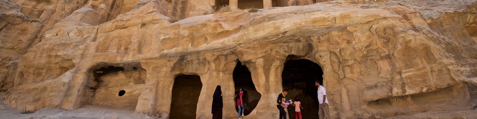 Little Petra featuring a gorge or canyon and heritage architecture as well as a small group of people