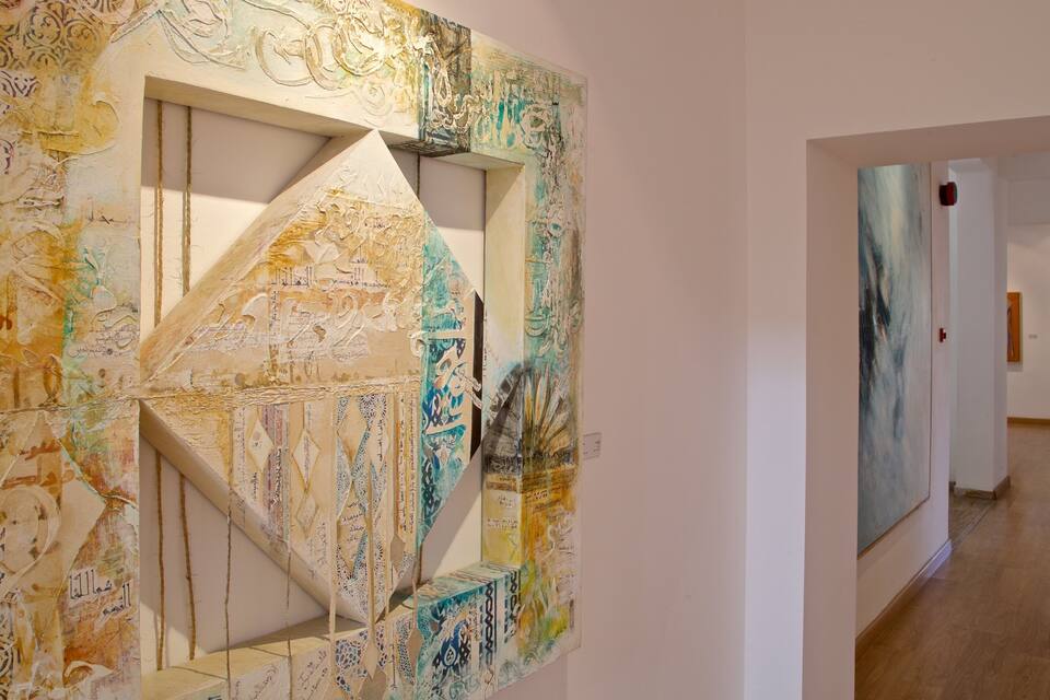An art gallery with abstract paintings and calligraphy on the walls.