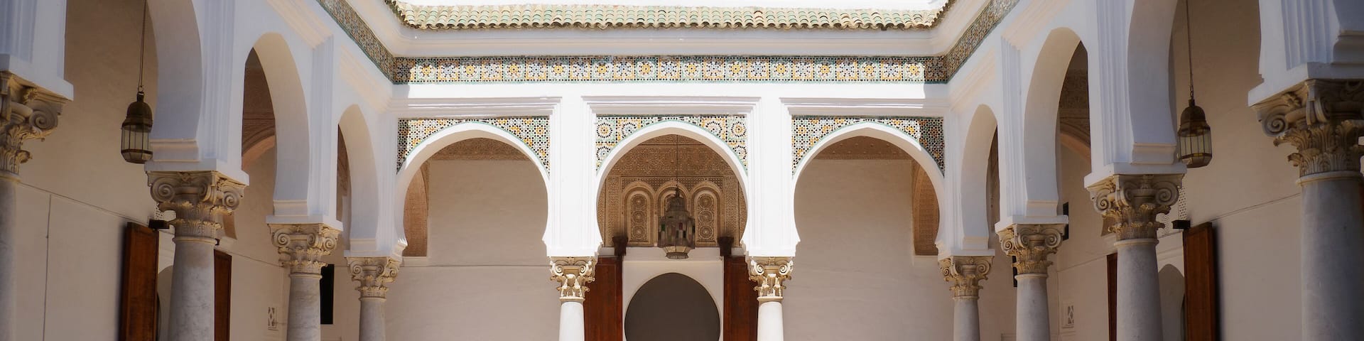 A courtyard with arches, columns, and a patterned floor.