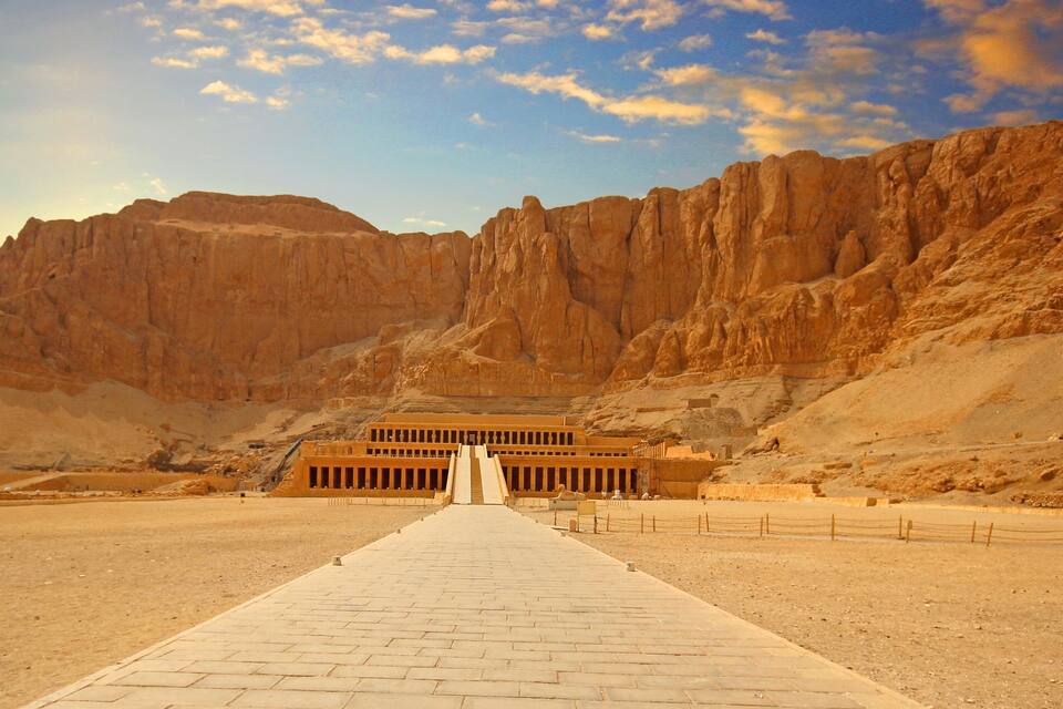 Un paisaje desértico con una gran estructura piramidal a lo lejos.
