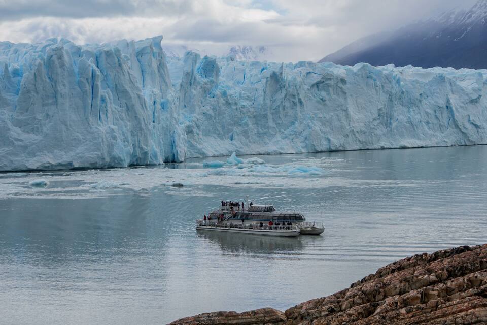 A glacier with a boat in the foreground.