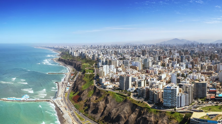 Aerial panorama of Lima, Peru along the coast also known as Circuito de Playas de la Costa Verde at a golden hour sunset
