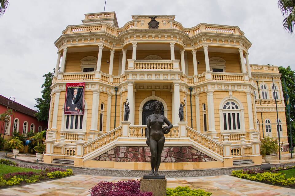 A neoclassical building with a statue in front.