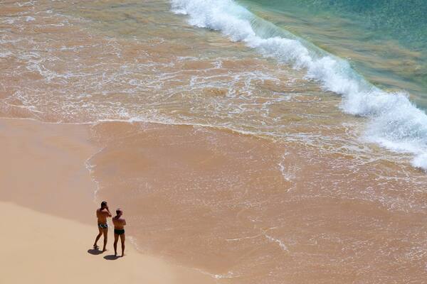 Sancho Beach which includes general coastal views and surf as well as a couple