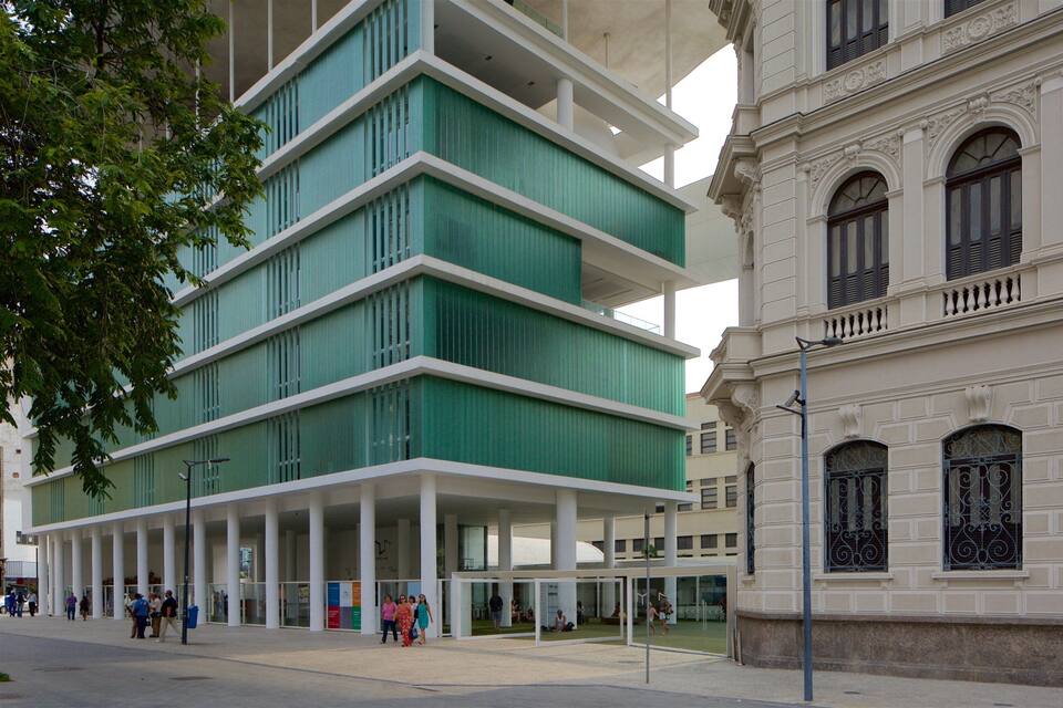 A modern building with green and white colors, and a classical building with arched windows.