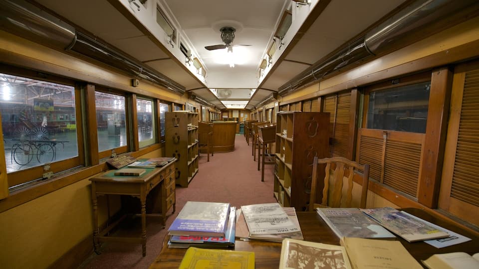 A train car with wooden desks and chairs, books, and papers.