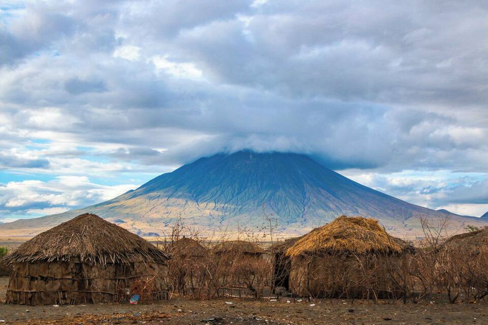 A mountain with huts in the foreground.