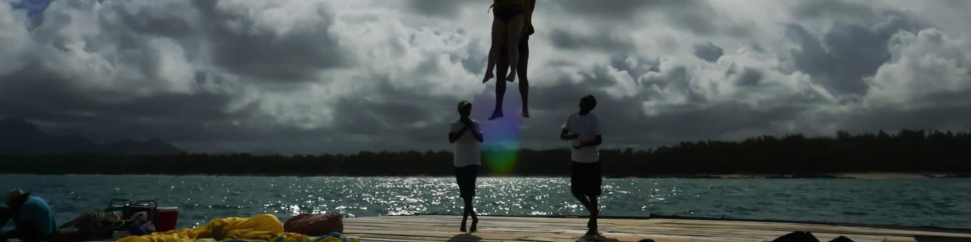 A parasailing activity with a large yellow parachute above the water.