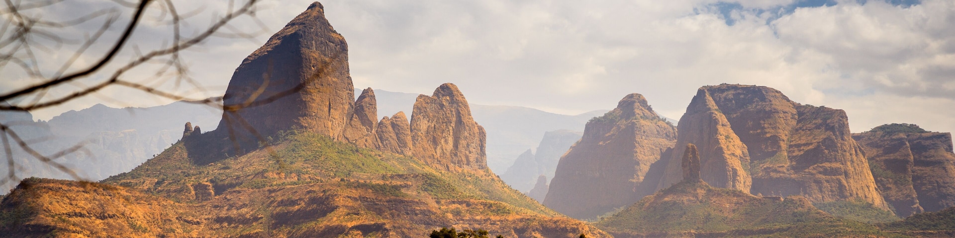 A desert landscape with prominent rock formations and sparse vegetation.