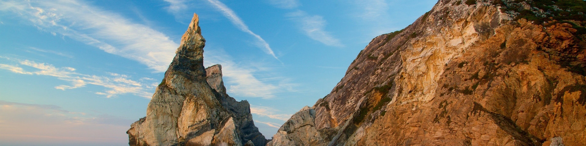Ursa Beach which includes general coastal views, a sunset and rocky coastline