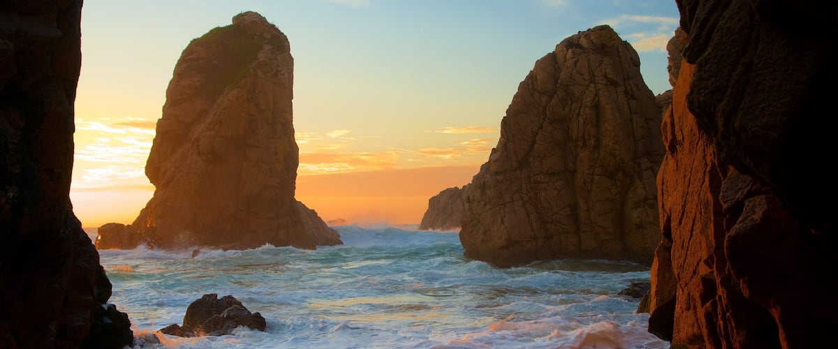 Ursa Beach featuring surf, a sunset and rugged coastline