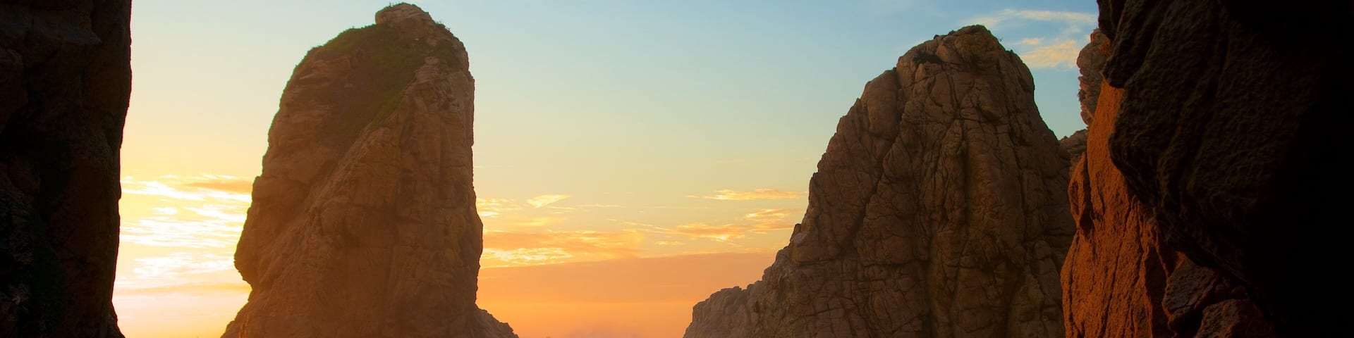 Ursa Beach featuring surf, a sunset and rugged coastline