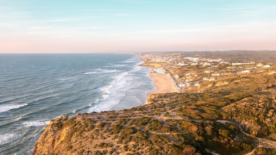 Sunset on the beach Praia Grande, Portugal. Beautiful sunset on the Portuguese beach Praia Grande, in Portugal. Beach of Praia Grande. View of Atlantic beach and big waves. Colares, Sintra, Portugal.