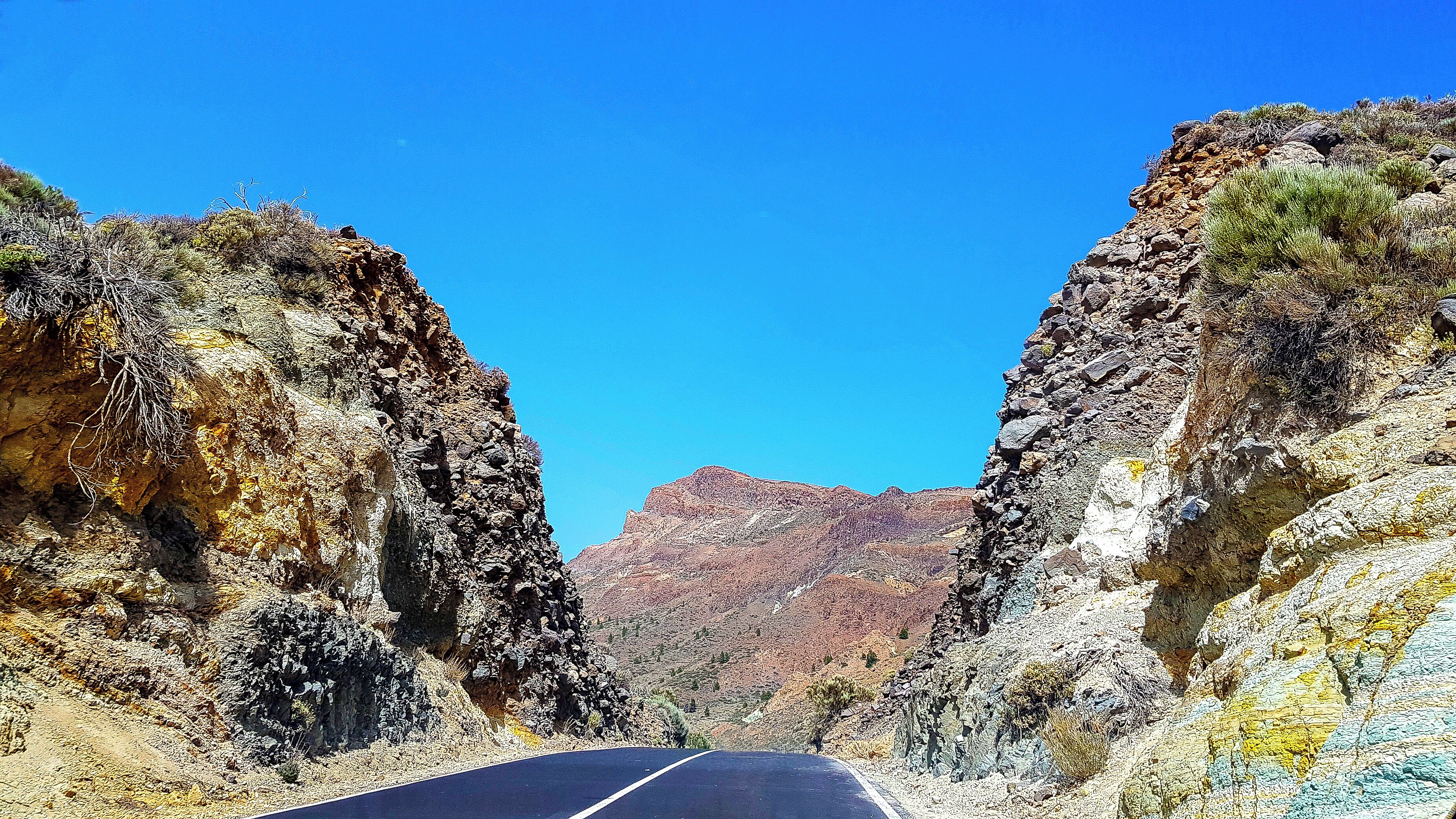 The roads around Teide National Park are breath taking in their own right! Where the road cuts through the rocks you can see the built up layered minerals from previous eruptions of the volcano!

The landscape changes colour abruptly, from blacks, yellows to reds and greys.